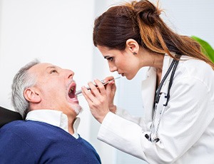 A dentist performing an oral cancer screening