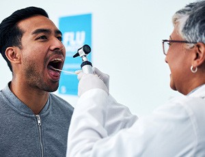 A dentist performing an oral cancer screening