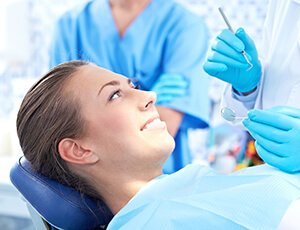 Woman in dental chair smiling at dentist