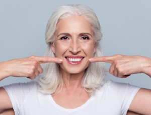 Senior woman pointing to smile