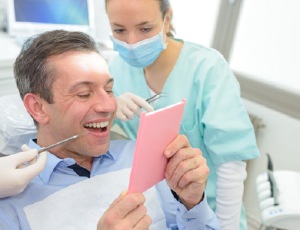 Man looking at smile in mirror