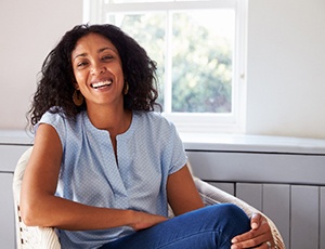 Woman with beautiful smile smiling while sitting in chair at home