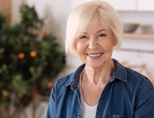 Older woman with dental implants in Harrisburg smiling at home