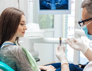 A dentist showing his patient a dental implant