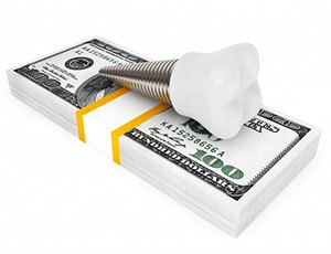 dental implant lying on top of a stack of money 