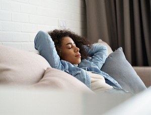 a woman relaxing in Harrisburg after dental implant treatment