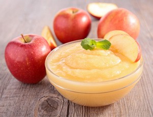 a bowl of applesauce on a wooden table