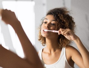 a woman brushing her dental implants in Harrisburg