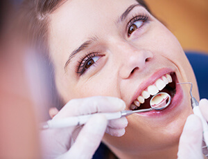 Smiling woman examined with dental tools