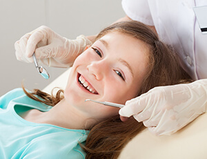 Smiling young girl in dental chair