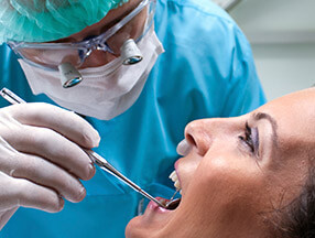 Dentist examining female patient in dental chair