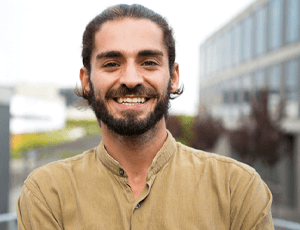 person smiling while standing in front of a building