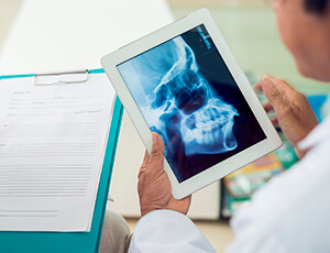 Dentist examines x-ray on tablet