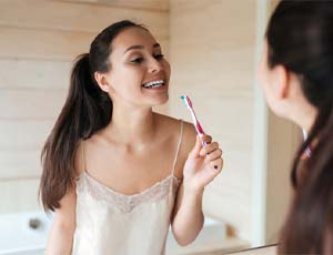 Woman getting ready to brush her veneers in Harrisburg