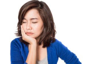 Woman with dental implants with jaw pain. 