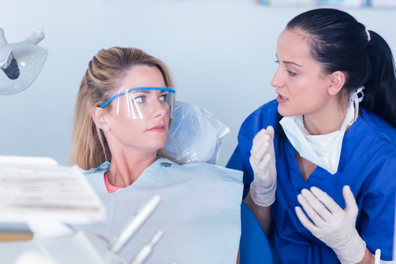 person talking to dentist about missing back tooth