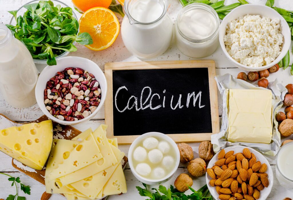 Chalkboard reading 'calcium' on table next to foods high in calcium